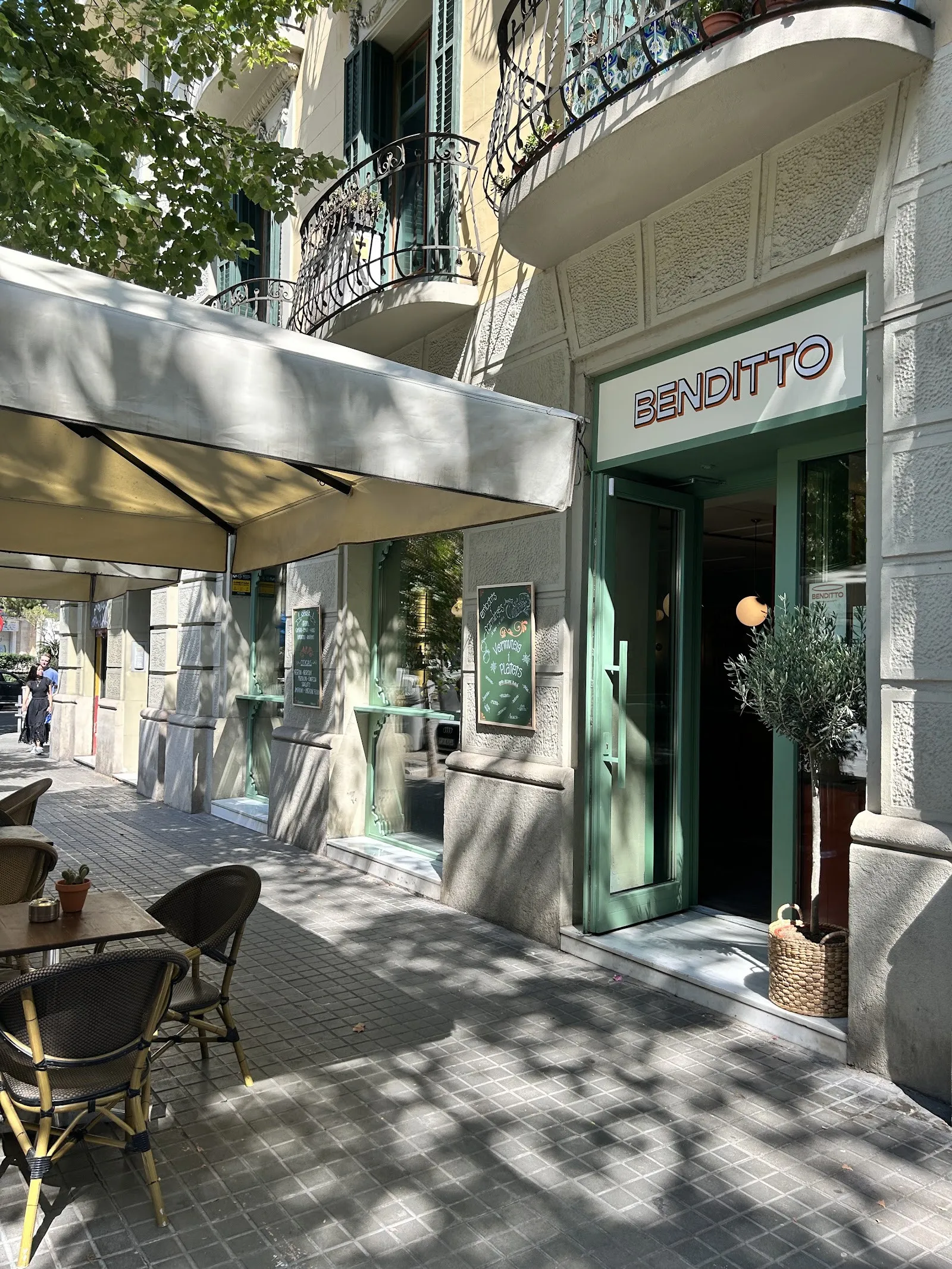Benditto’s front on Carrer de Bailèn, with its awning and chairs on the pavement